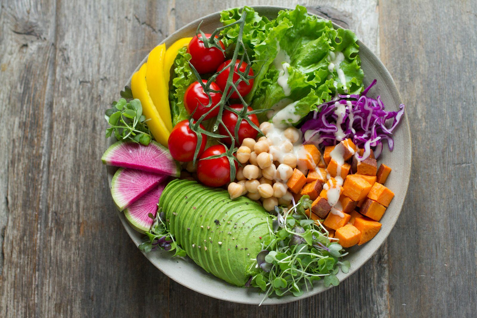Colourful plant-based bowl with avocado, chickpeas, sweet potato and fresh vegetables
